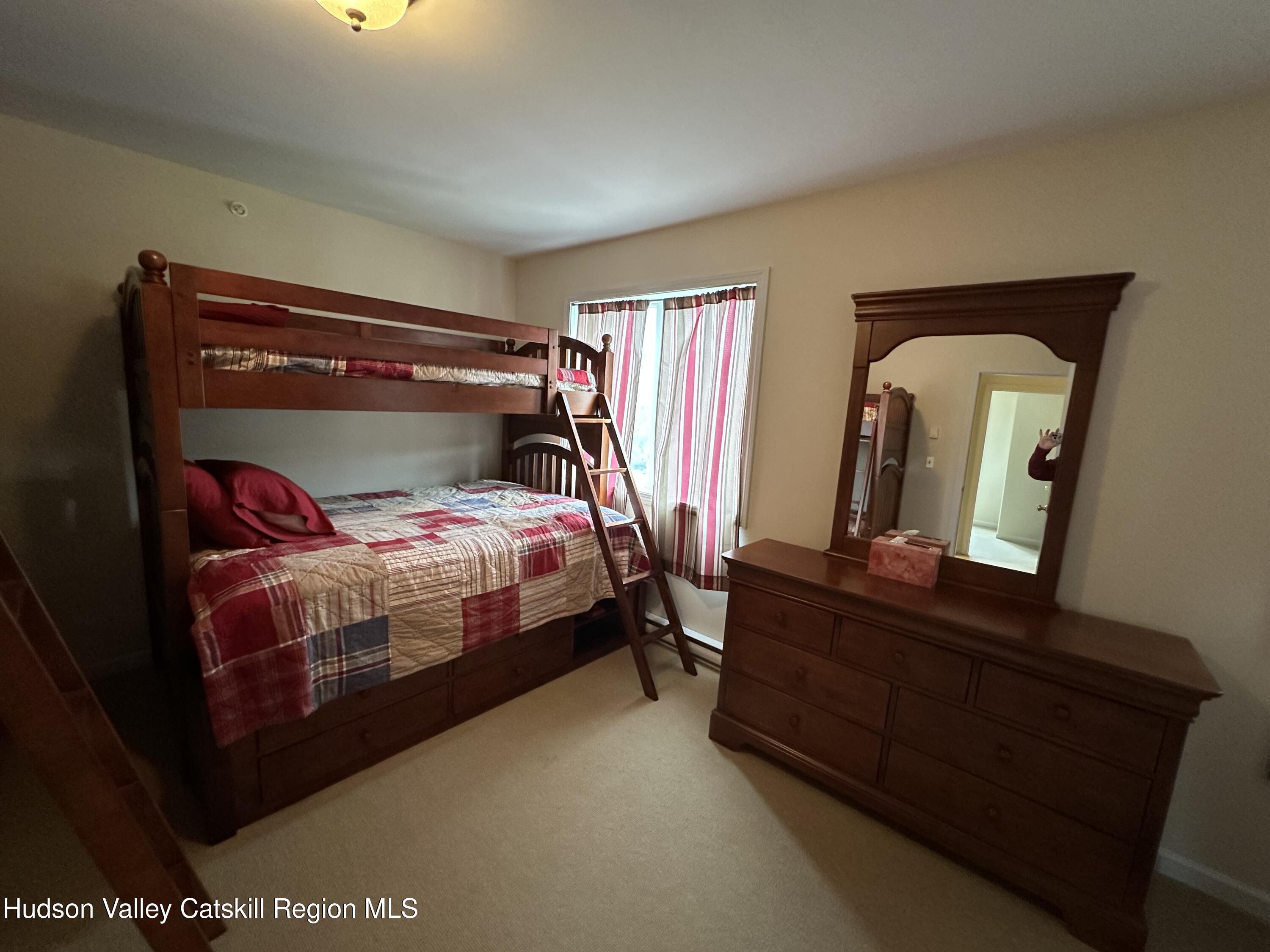 274 Brooksburgh Road, Unit 67 Hensonville, NY 12439 - Photo 29 of 36 a bedroom with a bed and mirror