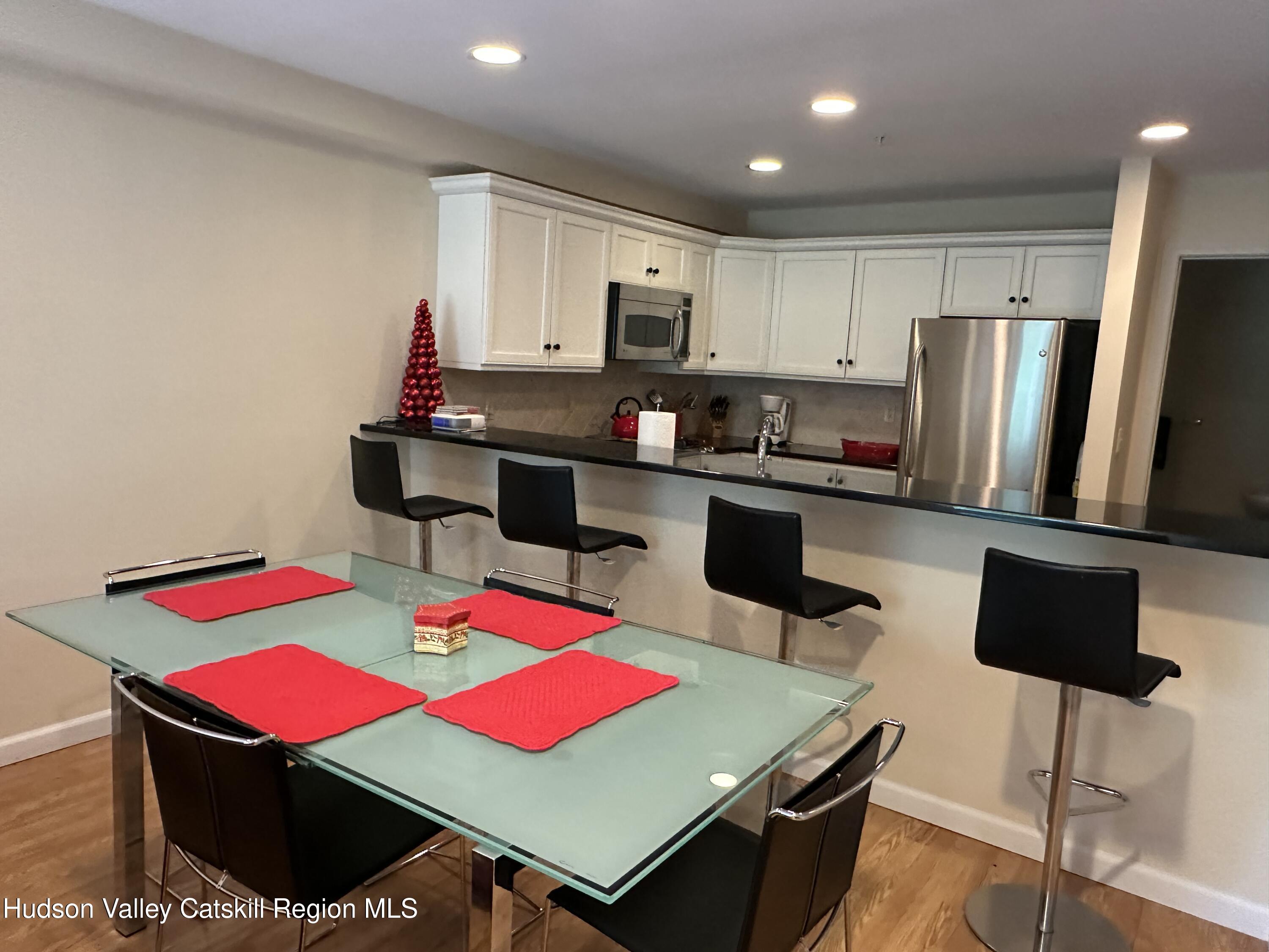 274 Brooksburgh Road, Unit 67 Hensonville, NY 12439 - Photo 10 of 36 a kitchen with a table chairs and a refrigerator