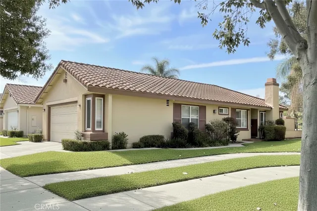 a front view of a house with a yard and potted plants