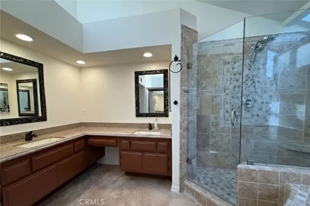 a bathroom with a double vanity sink toilet and shower