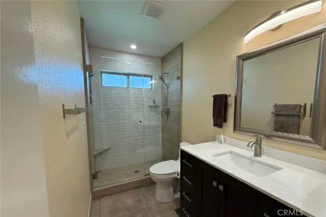 a bathroom with a double vanity sink toilet and shower