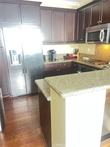 a kitchen with granite countertop a refrigerator a stove a sink and dishwasher