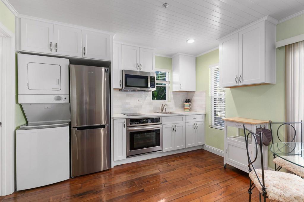 2738 MacKinnon Ranch Road Cardiff-by-the-Sea, CA 92007 - Photo 23 of 58 a kitchen with a refrigerator stove and wooden cabinets