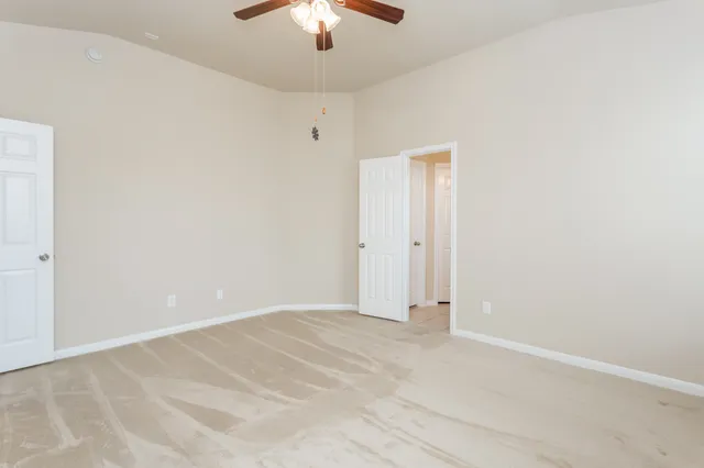 an empty room with chandelier fan