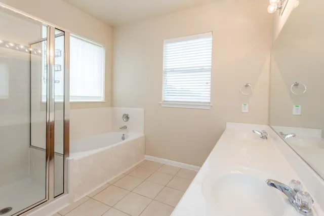 a spacious bathroom with a tub shower and window