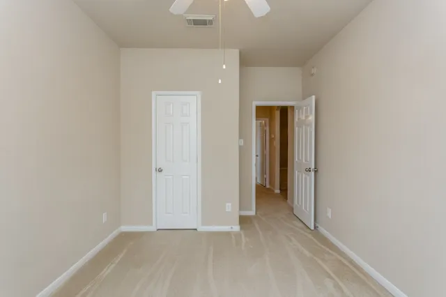 a view of an empty room with closet and a window