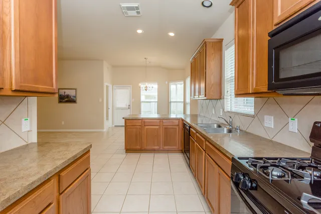 a kitchen with stainless steel appliances granite countertop a stove a sink and a microwave
