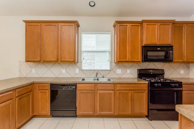 a kitchen with stainless steel appliances granite countertop a stove a sink and a microwave