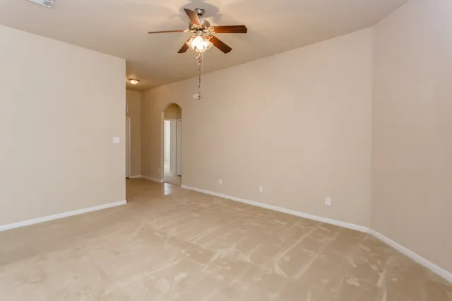 an empty room with a ceiling fan and a fan