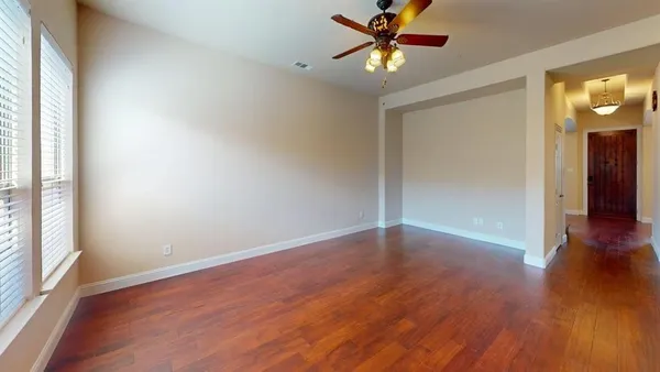 a view of a livingroom with wooden floor and a ceiling fan