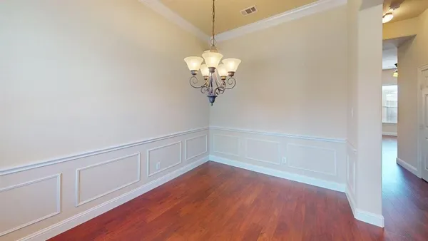 a view of a room with wooden floor and chandelier