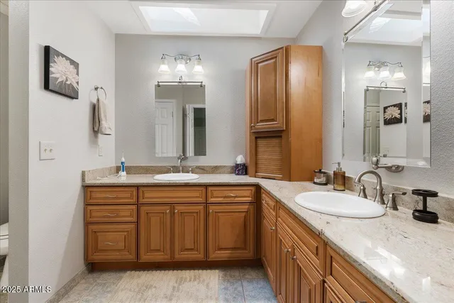 a bathroom with a granite countertop double vanity sink and a mirror