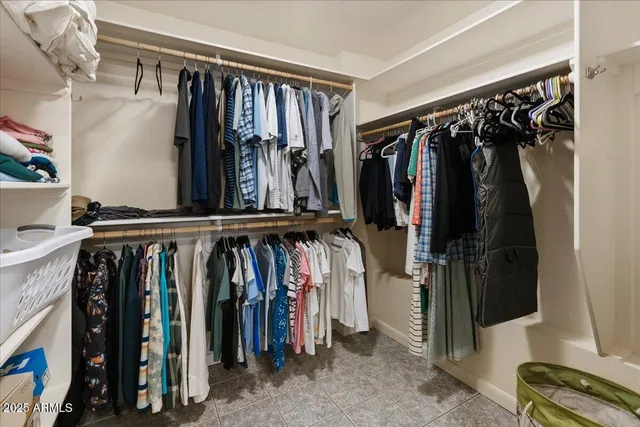 a view of walk in closet with clothes and shoes