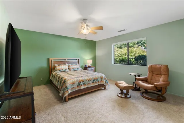 a spacious bedroom with a bed and a chair