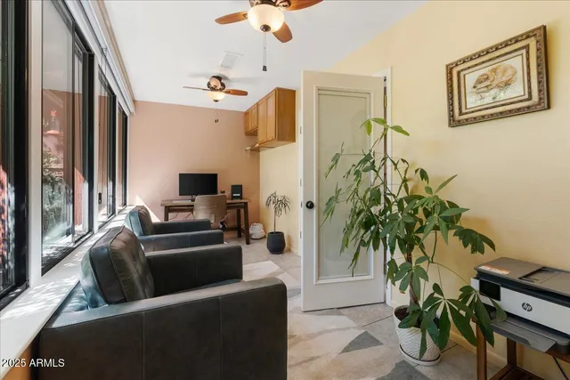 a living room with furniture potted plant and a flat screen tv