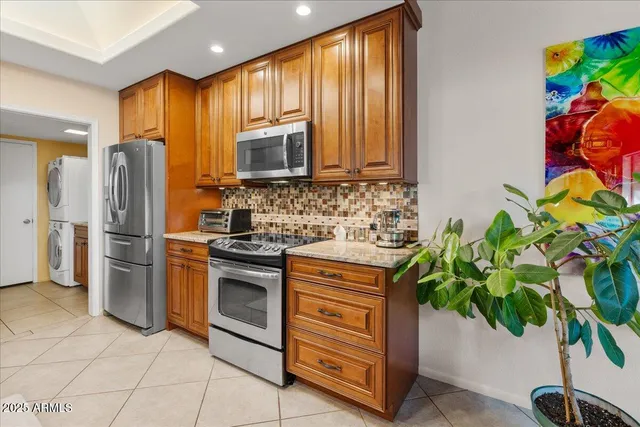a kitchen with stainless steel appliances a stove a sink cabinets and a window
