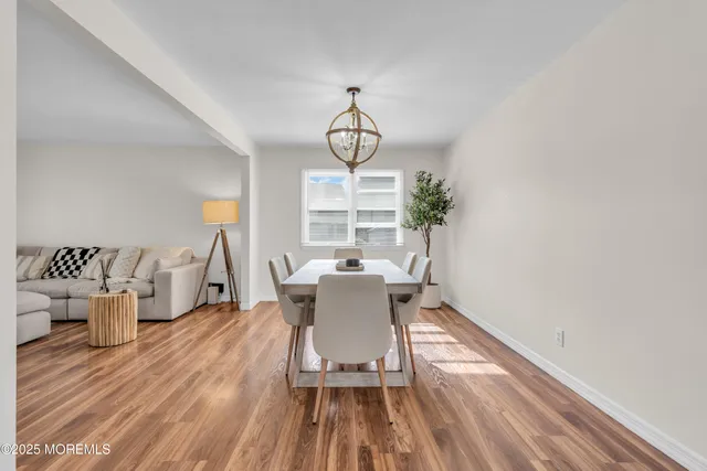 a dining room with wooden floor and a chandelier