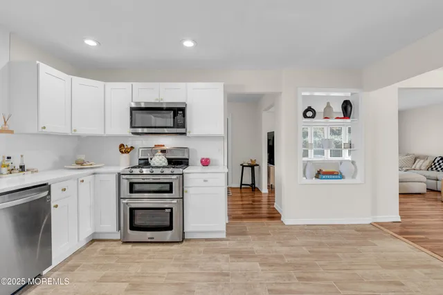 a kitchen with stainless steel appliances a stove top oven a sink a microwave and a refrigerator