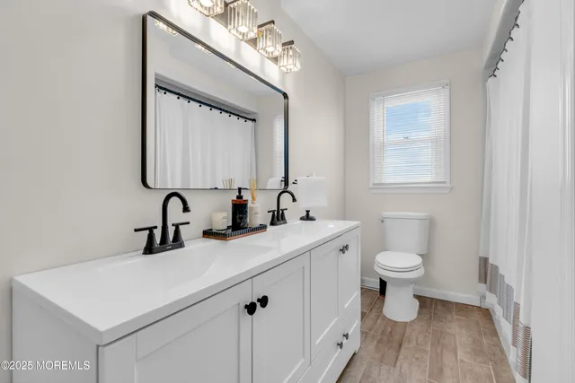 a bathroom with a toilet a sink a mirror and vanity