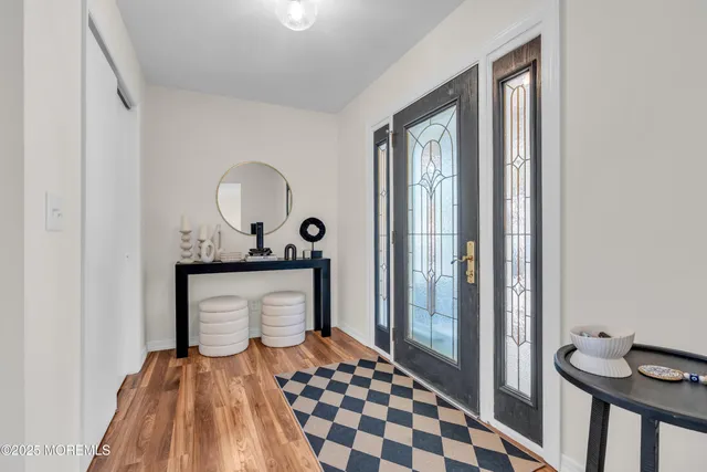 a view of a hallway with wooden floor and a bathroom