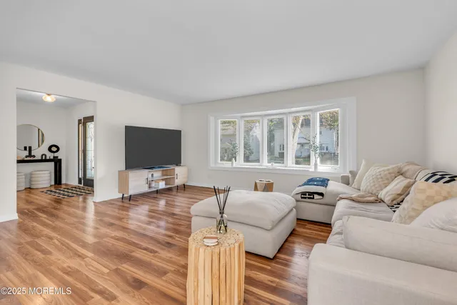 a living room with furniture a flat screen tv and a large window
