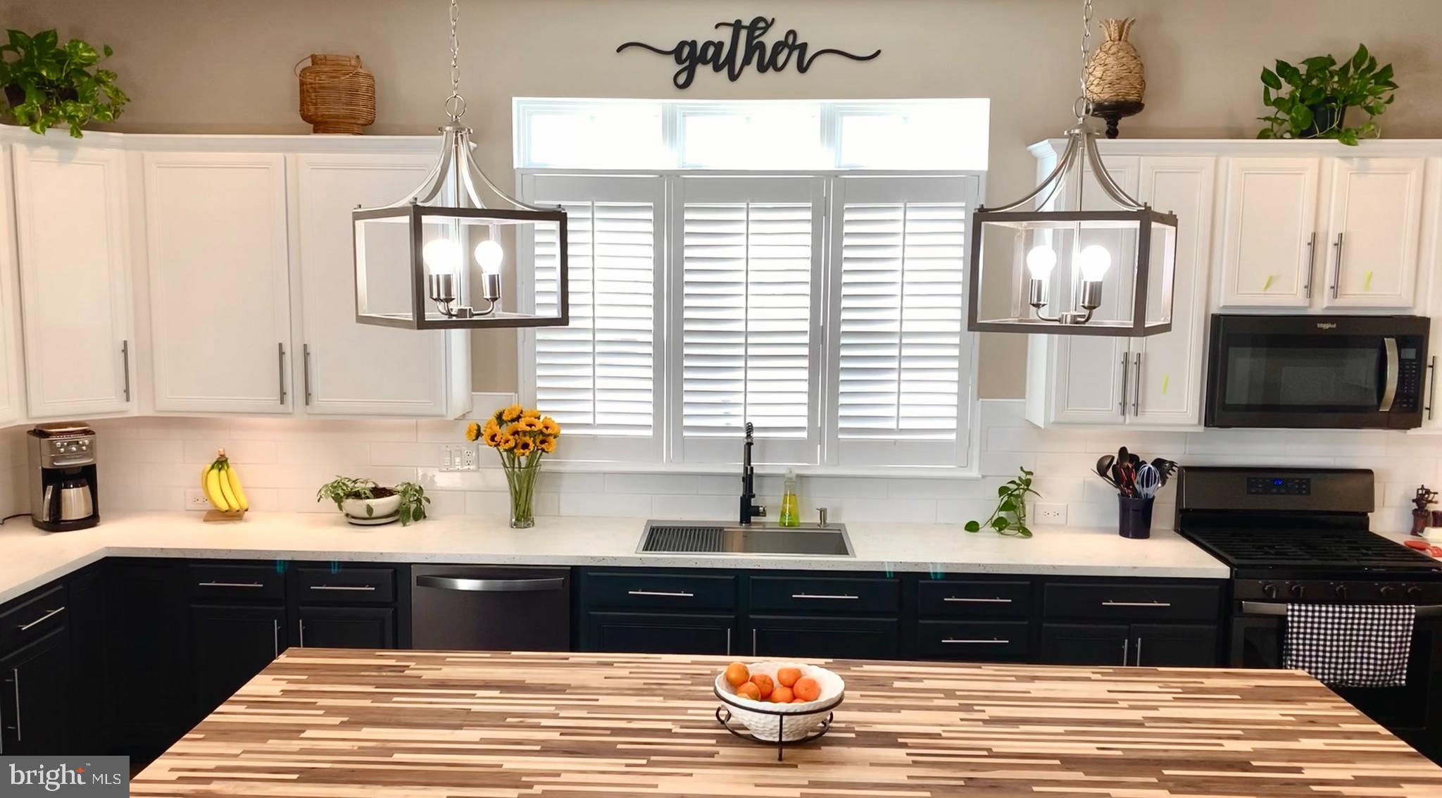 9054 Roaring Spring Loop Bristow, VA 20136 - Photo 3 of 4 a kitchen with a chandelier and a wooden floor