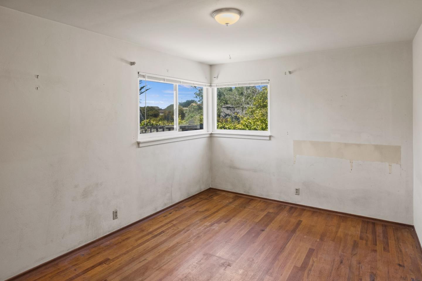 30 Acropolis Street Pacific Grove, CA 93950 - Photo 19 of 36 an empty room with wooden floor and windows