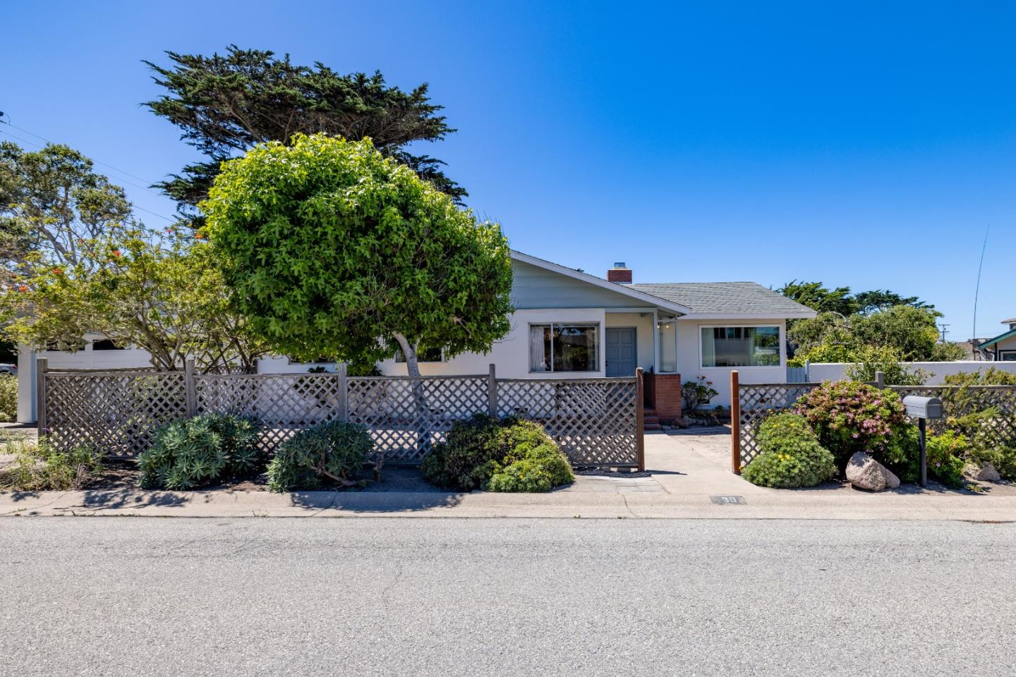 30 Acropolis Street Pacific Grove, CA 93950 - Photo 34 of 36 front view of a house with potted plants and a large tree