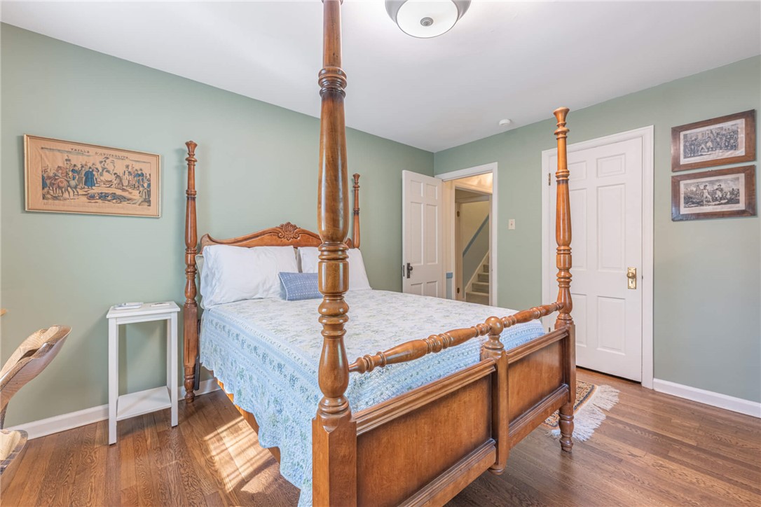 156 West Hadley Road Dayton, OH 45419 - Photo 21 of 71 This inviting bedroom offers hardwood floors and convenient access to a staircase, ensuring comfort and easy navigation.