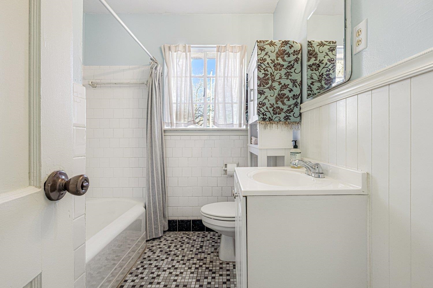 4490 Garnett Road Memphis, TN 38117 - Photo 14 of 18 Full bathroom with wainscoting, vanity, shower / bath combo, and light tile patterned floors
