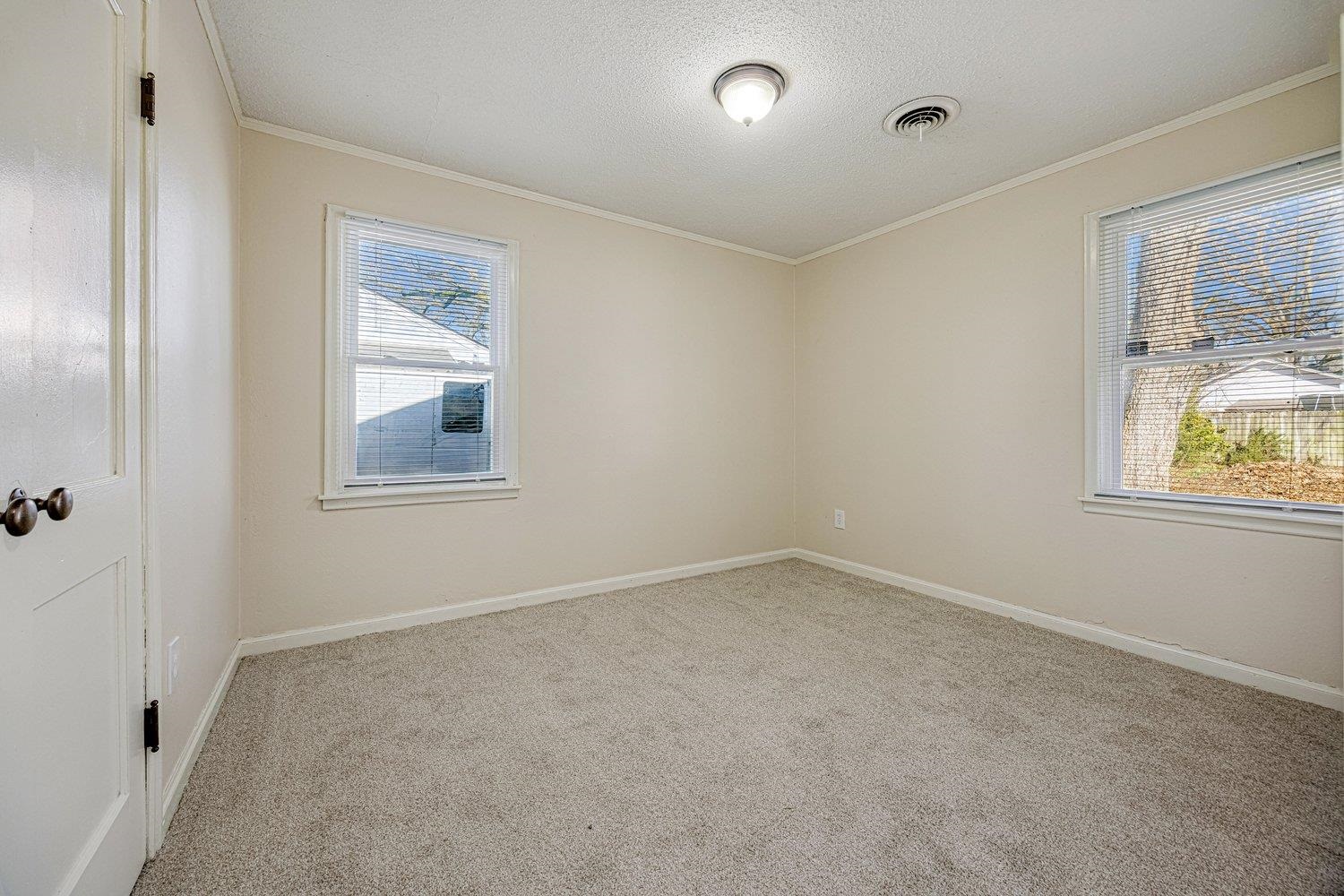 4490 Garnett Road Memphis, TN 38117 - Photo 16 of 18 Unfurnished room featuring light carpet, ornamental molding, and a textured ceiling
