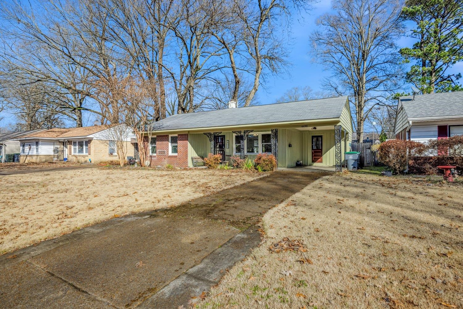 4490 Garnett Road Memphis, TN 38117 - Photo 3 of 18 View of front of house with an attached carport, driveway, board and batten siding, brick siding, and covered porch
