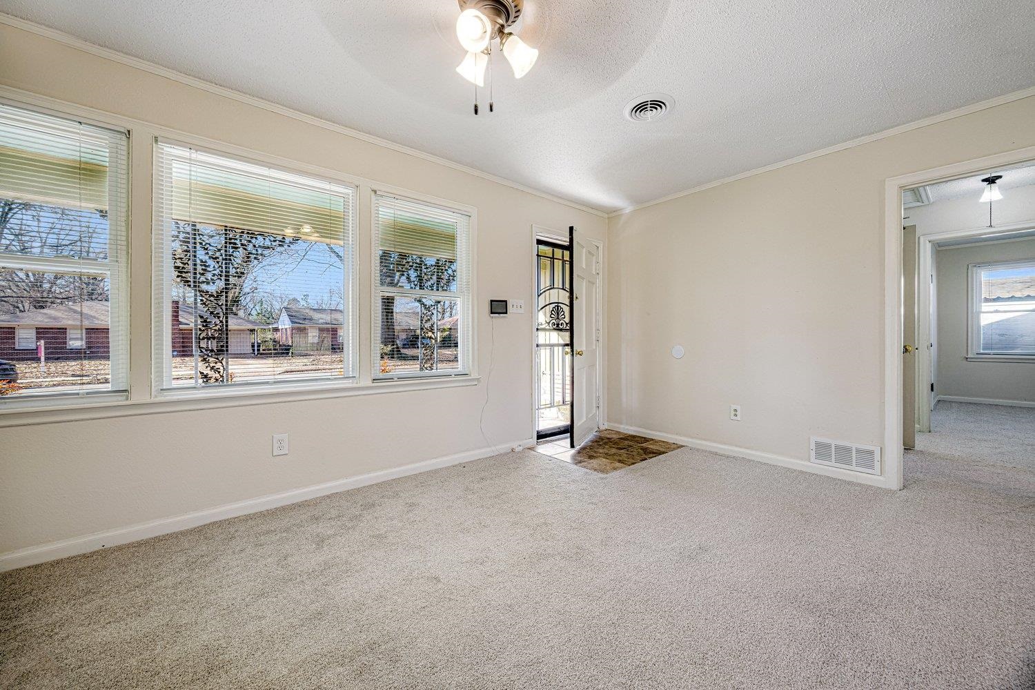4490 Garnett Road Memphis, TN 38117 - Photo 6 of 18 Foyer entrance featuring ceiling fan, light colored carpet, a textured ceiling, and ornamental molding