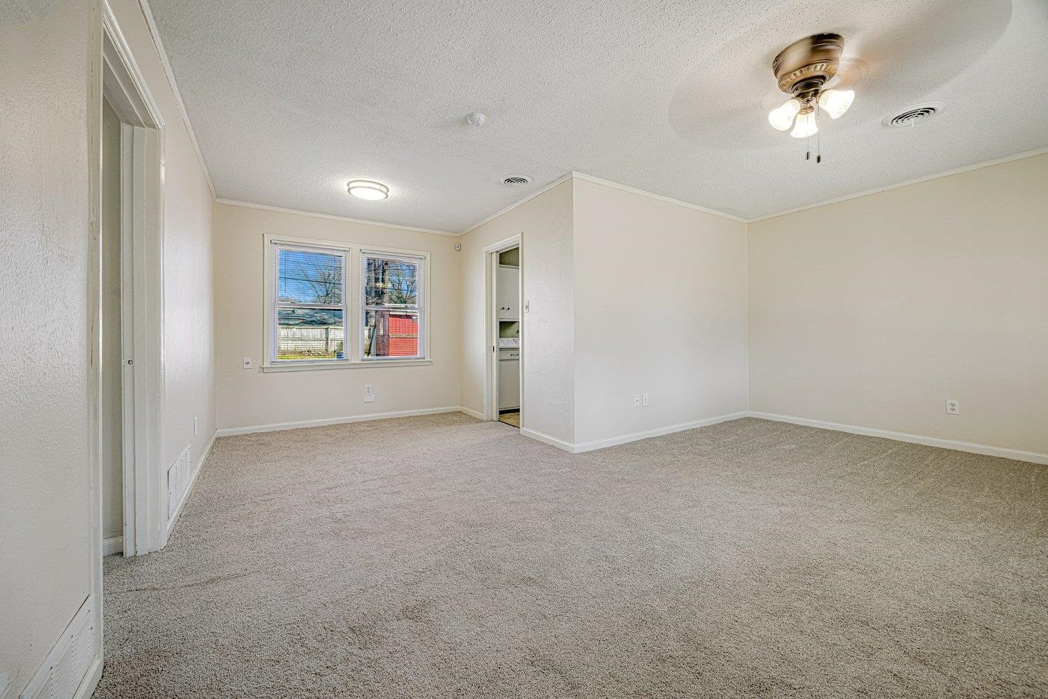 4490 Garnett Road Memphis, TN 38117 - Photo 8 of 18 Spare room with crown molding, light carpet, a textured ceiling, and a ceiling fan