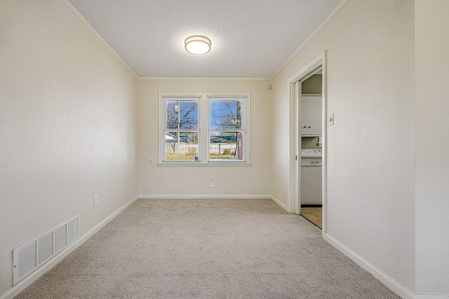 4490 Garnett Road Memphis, TN 38117 - Photo 9 of 18 Unfurnished room with a textured wall, a textured ceiling, ornamental molding, and light carpet