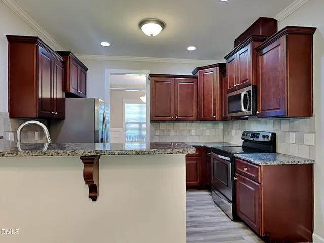 a kitchen with stainless steel appliances granite countertop a sink stove and microwave