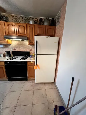 a kitchen with granite countertop a refrigerator and a stove top oven