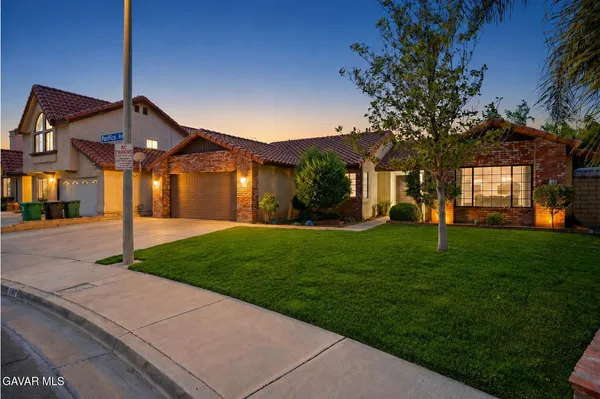 a front view of a house with a garden and yard