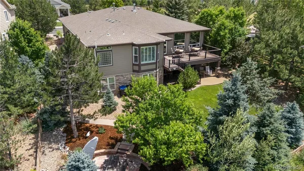 an aerial view of a house with table and chairs under an umbrella