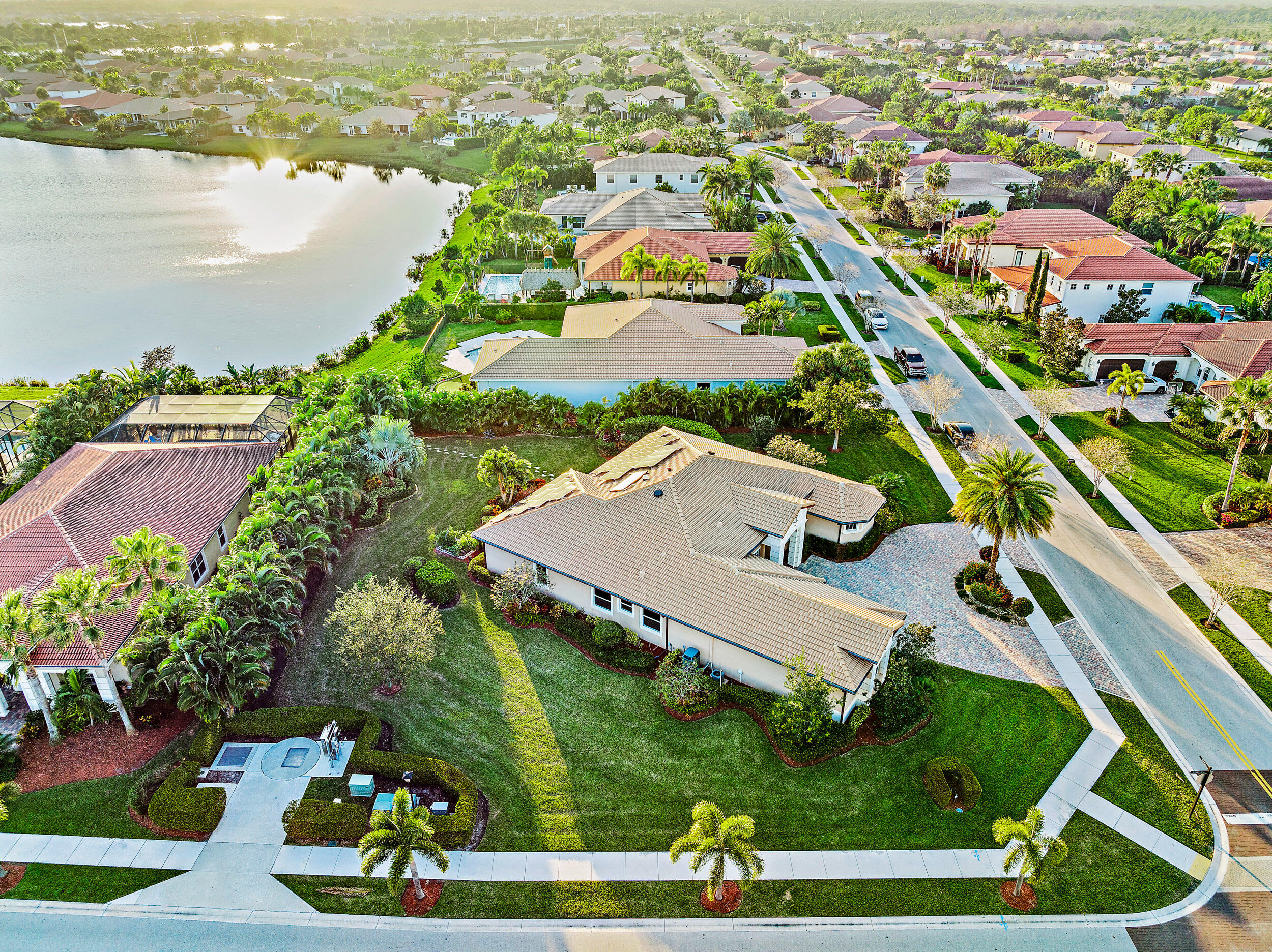 an aerial view of residential houses with outdoor space and lake view in back