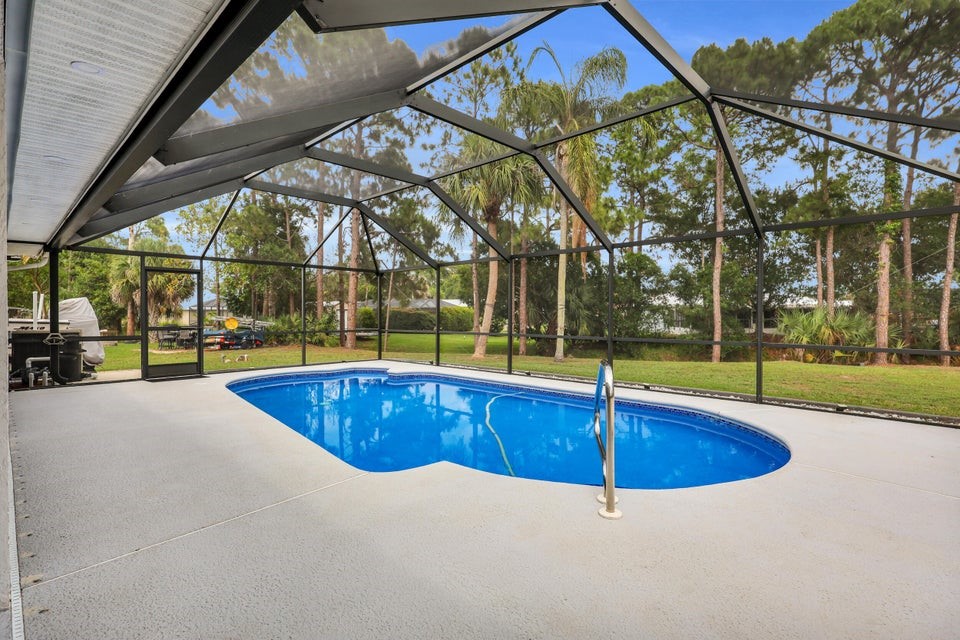 1950 Southwest Logwood Road Port St. Lucie, FL 34953 - Photo 3 of 32 a swimming pool with outdoor seating and yard