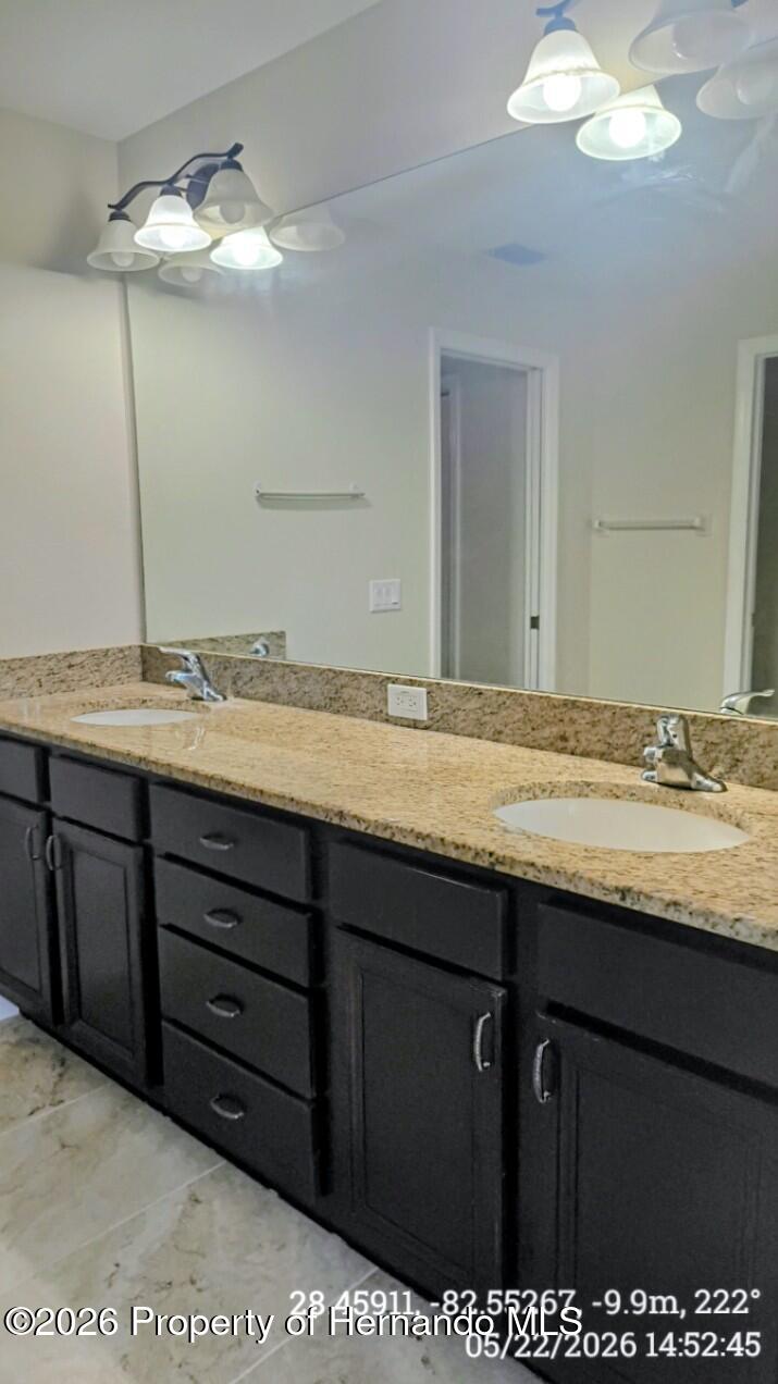 10244 Heathcliff Street Spring Hill, FL 34608 - Photo 21 of 30 a bathroom with a granite countertop sink and a mirror