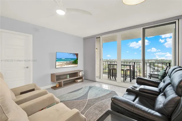 a living room with furniture tv and a floor to ceiling window