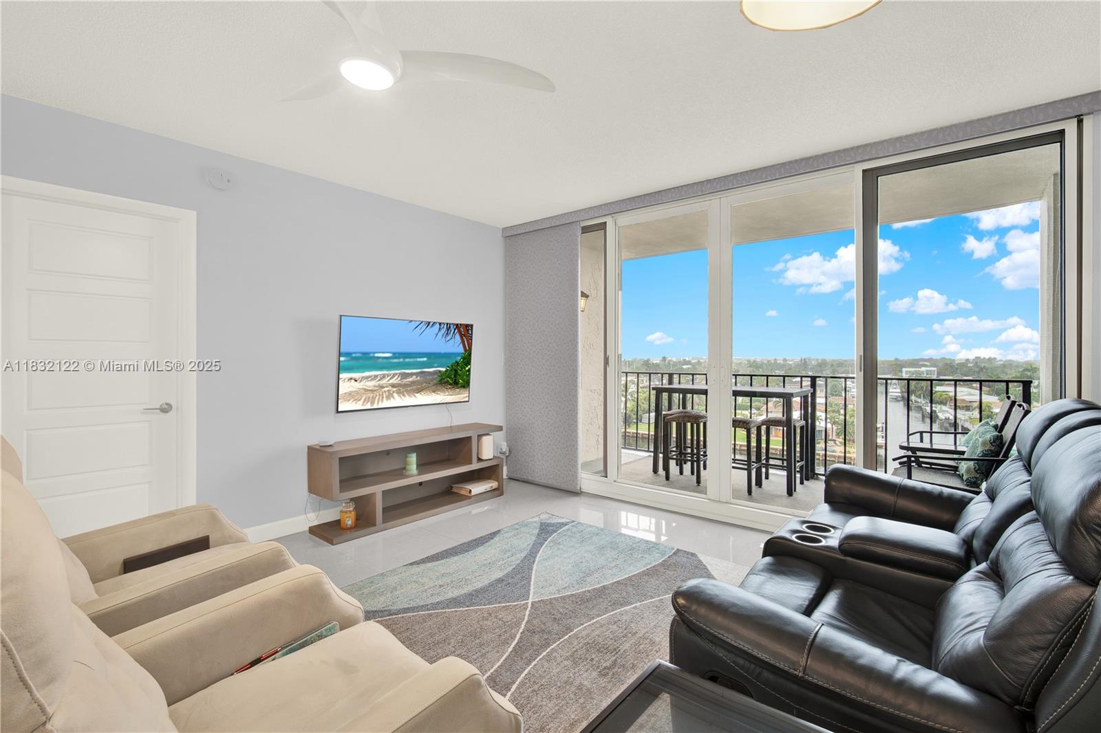 521 North Riverside Drive, Unit 707 Pompano Beach, FL 33062 - Photo 13 of 50 a living room with furniture tv and a floor to ceiling window