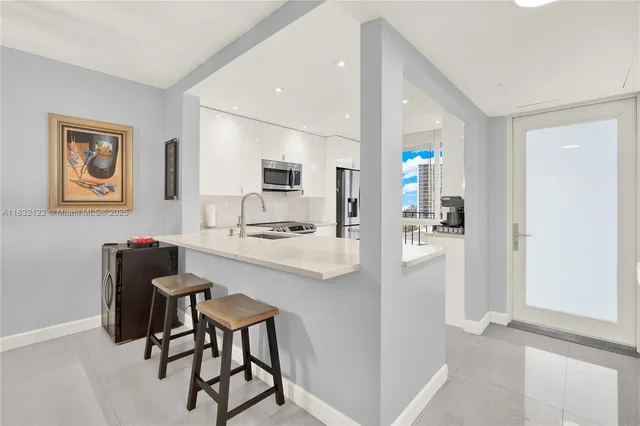 a kitchen with stainless steel appliances kitchen island granite countertop a refrigerator and a stove top oven