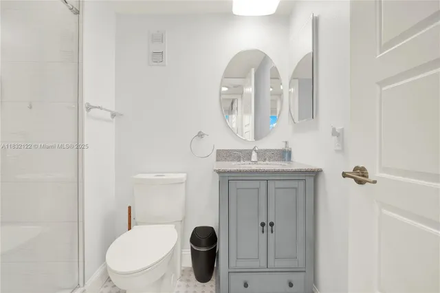 a bathroom with a toilet a sink and mirror