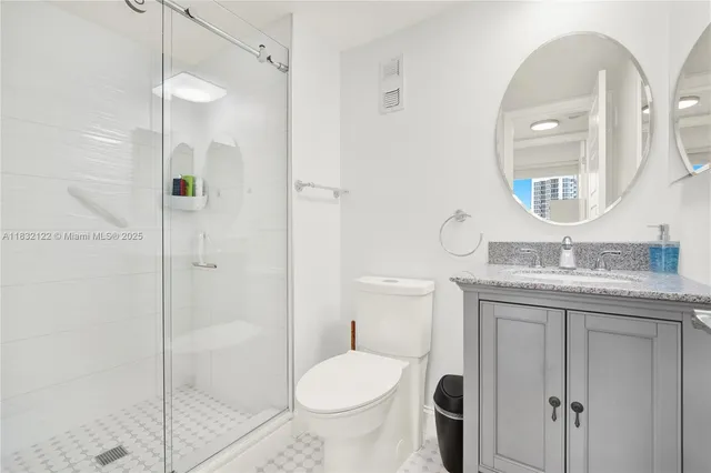 a bathroom with a granite countertop toilet sink and shower