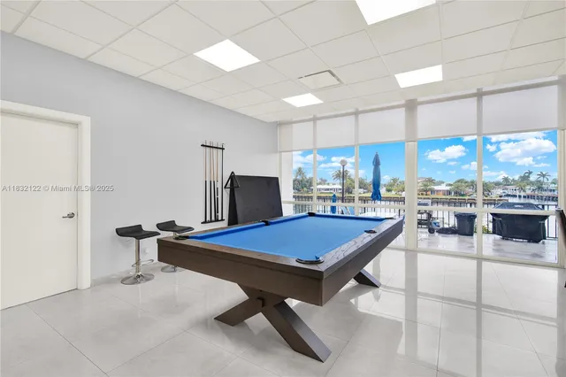 a room with pool table and windows