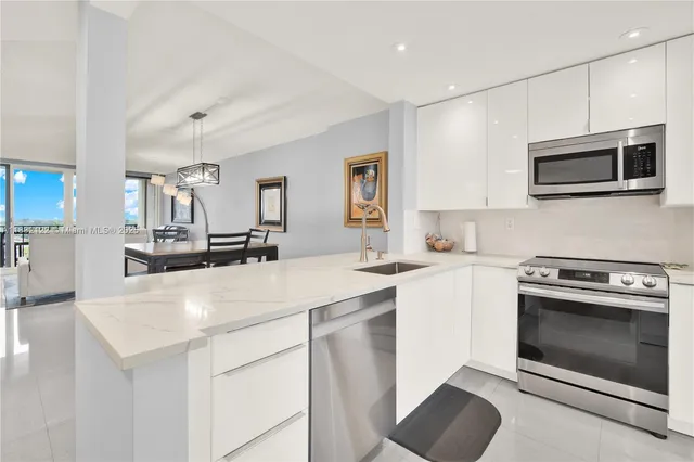 a kitchen with stainless steel appliances a stove sink microwave and cabinets