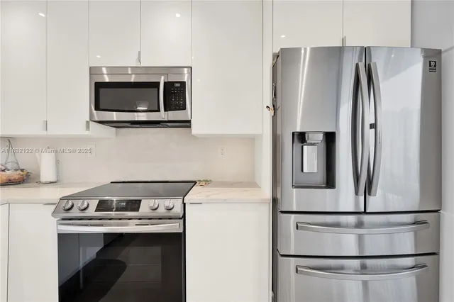 a kitchen with stainless steel appliances a refrigerator sink and microwave